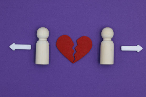 istock Two Married Men Wooden Figurines Experiencing Divorce Separation with white arrows and broken heart on purple background 2148298836