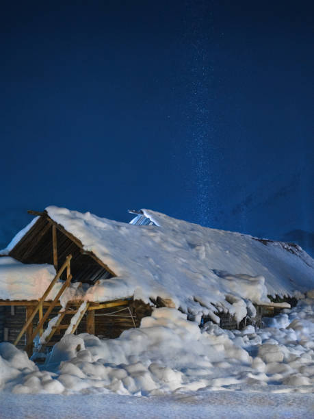 There is a gap in the roof of the wooden house in the picture. It was snowing heavily at the time, and the light from the gap illuminated the snow.