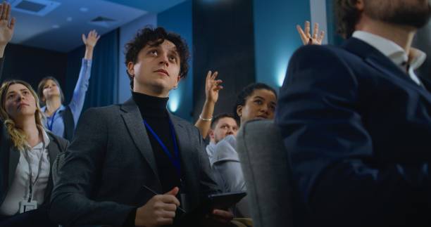 istock Multiethnic press workers raise hands sitting in the conference room 2148299722