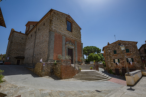 Piazza dei Caduti per la libertà, Lucignano, Italy - 23 of May 2022: Walking streets small historic town Lucignano. View of church Collegiata di San Michele Arcangelo facade.