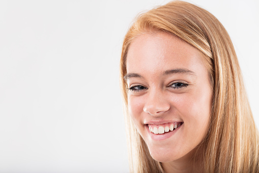 Blonde-haired young woman beams with a genuine, heartfelt smile