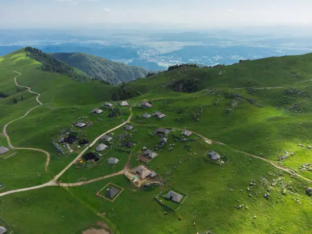 Photo of Aerial View of Mountain Cottages on Green Hill of Velika Planina Big Pasture Plateau, Alpine Meadow Landscape, Slovenia