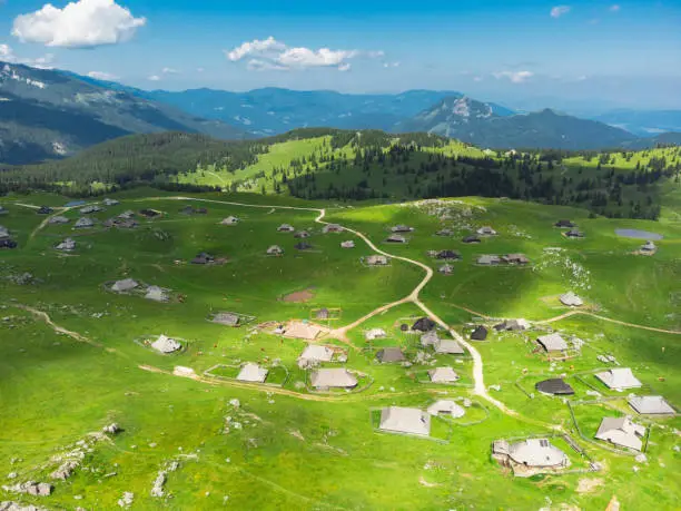 Photo of Aerial View of Mountain Cottages on Green Hill of Velika Planina Big Pasture Plateau, Alpine Meadow Landscape, Slovenia