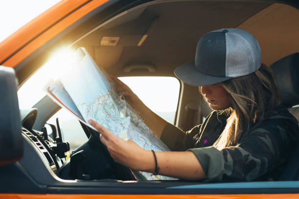istock Attractive woman who looks at the map inside to her van 2148302617