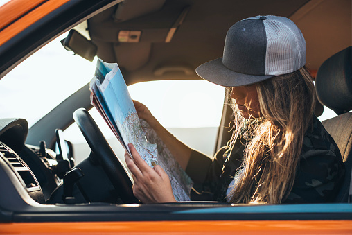 Nice blonde woman with map inside orange van