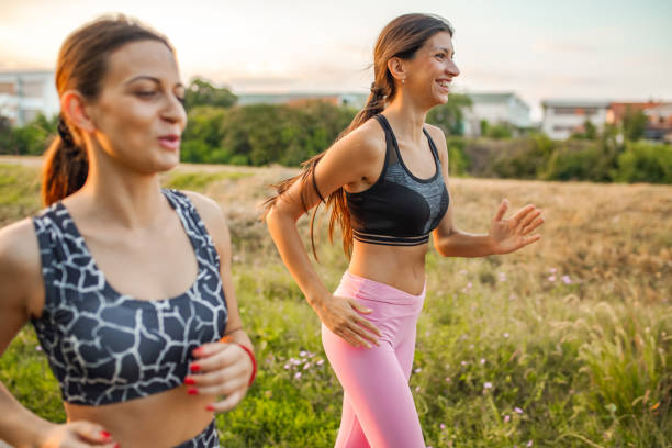 istock Two fit female friends jogging together in nature 2148302883