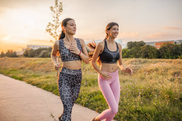istock Two fit female friends jogging together at sunset 2148303084