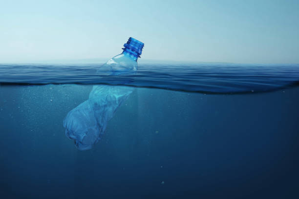 istock Garbage plastic bottle floats in blue sea water with underwater. Pollution of the environment and oceans. 2148303101