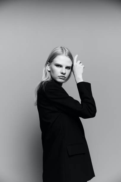 istock Charming young professional model puts her hand to her face cheek in the studio. The concept for the new collection. Classic black and white photo 2148303492