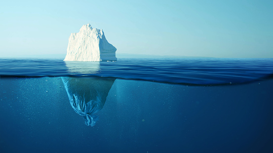 Iceberg with a plastic garbage bag underwater, the concept of pollution of the oceans and nature. Garbage in the water and melting glaciers. Environmental pollution