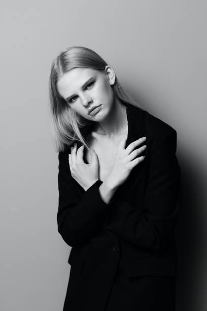 istock A stylish professional model crosses her arms on her chest and holds a jacket while posing in the studio. Fashionable stylish photo. Concept for clothing brands 2148303575