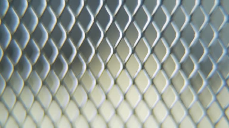 A hyper macro shot of a metal grid, steel pattern, iron industrial texture, aluminum material, super slow motion, Full HD 120 fps, tilt up smooth movement, blurry DOF