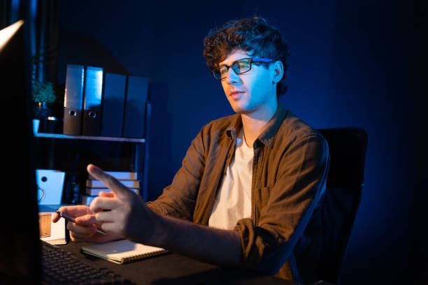 istock Businessman concentrating on pc on project at neon light office. Gusher. 2148304082