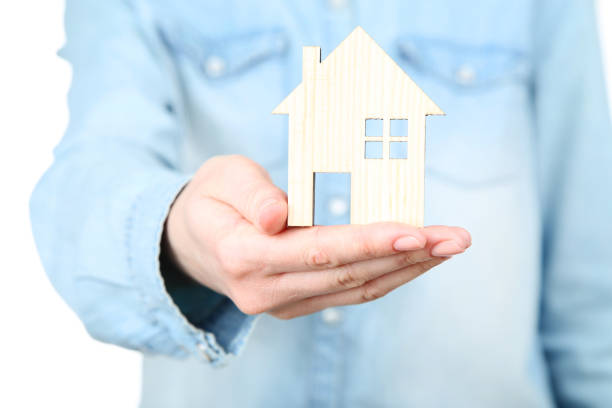 istock Female hand holding wooden house model 2148304473