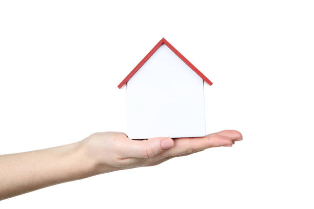 istock Female hand holding wooden house model on white background 2148304719