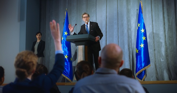 Confident politician makes an announcement, delivers campaign speech, gives interview to journalists and media. Mature representative of the European Union performs at press conference. Election day.