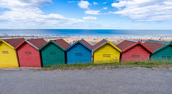 Multicoloured beach huts on a beautiful summer day with beach and horizon