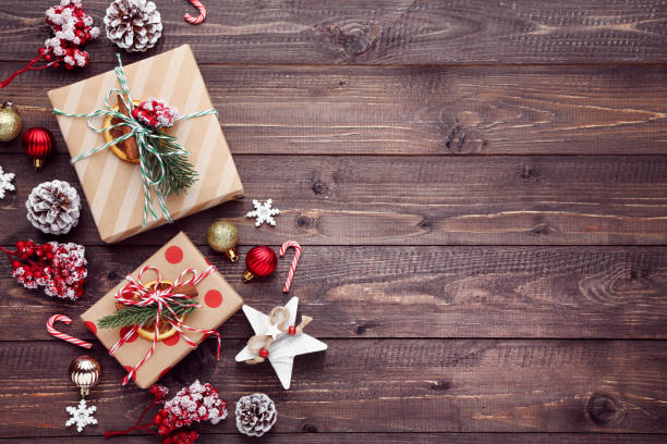 istock Gift boxes with ornaments on brown wooden background 2148307273