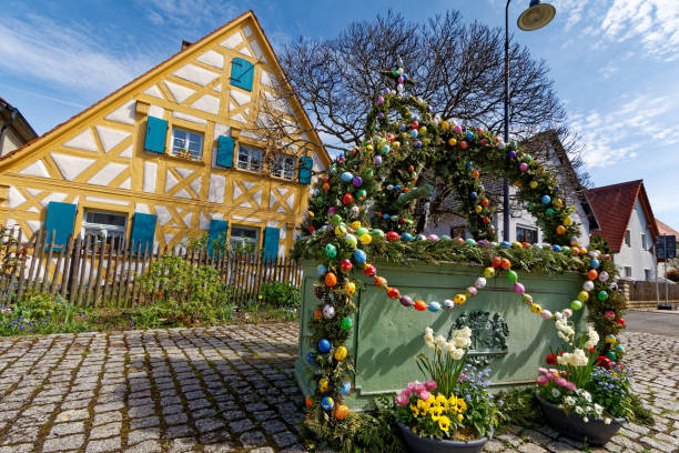 On the marketplace of the small town Auma in Thuringia, Germany is at Easter decorated the fountain with many colorful Easter eggs,