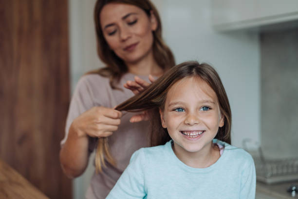 istock Lovely mother making braids on cute daughter's head. 2148308276