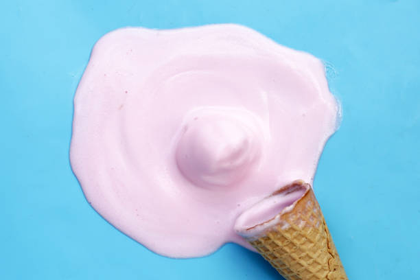 istock Melting ice cream balls with waffle cone on blue background. 2148310088