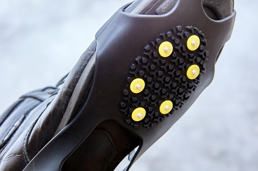 Overlay anti-slip spikes on soles of winter shoes to improve traction and prevent slipping during icy conditions.