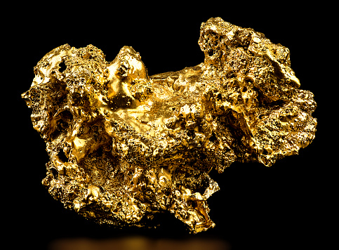 Gold nugget isolated on a black background. Gold ore.