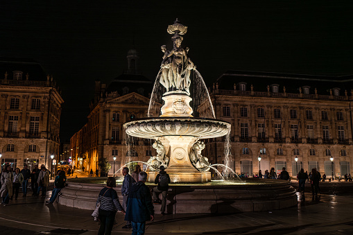 Bordeaux, France - April 6th, 2024: Bordeaux, Le Bourse quarter fountain at night with tourists