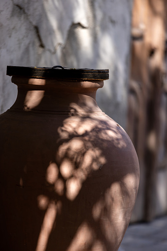 Ceramic clay pot in shadowed location, part of UAE heritage. High quality photo.