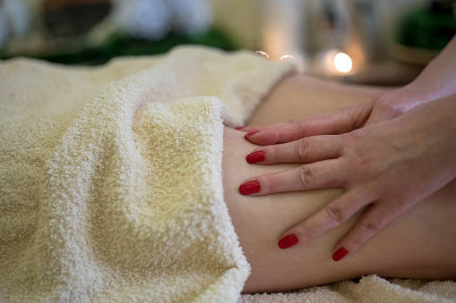 Luxury, wellness and zen spa massage on a young woman back, relaxing and stress free at a resort or center. Female enjoying healing treatment by a masseuse, pamper while massaging for muscle relief