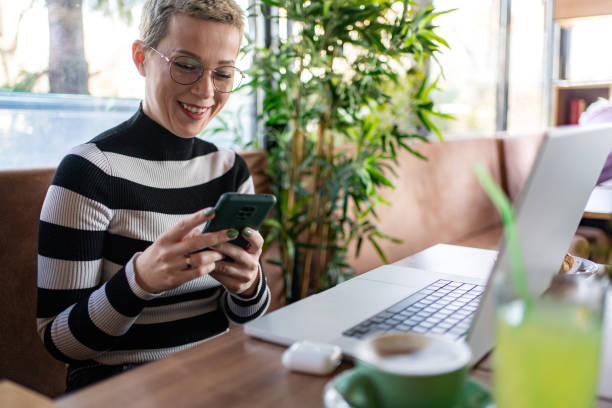 istock Businesswoman using smartphone while working in coffee shop 2148316485
