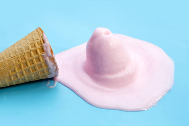 istock Melting ice cream balls with waffle cone on blue background. 2148317222
