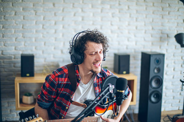 istock Guitar player recording music with condenser microphone in a home studio 2148317881