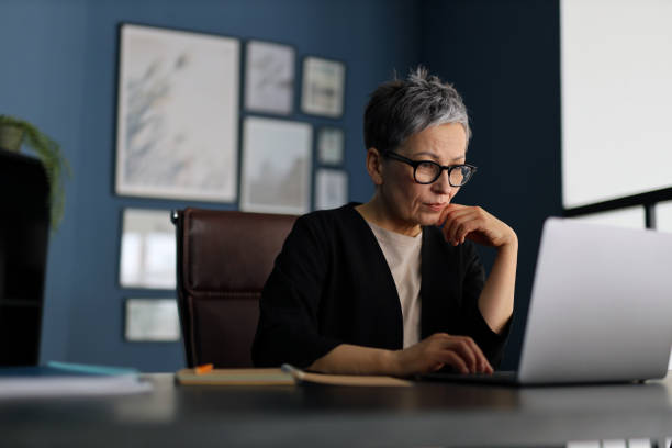 istock A mature entrepreneur, immersed in work, sits at a modern office desk, contemplating with dedication. 2148318030