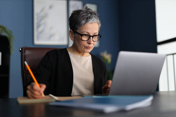 istock A woman diligently writes on her laptop at her modern workplace, epitomizing professionalism and dedication. 2148318039