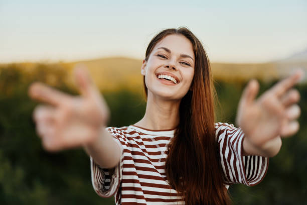 istock Woman smiling while looking at the camera and pulling her hands to the camera close-up in nature with a view of the mountains. Happy travel lifestyle follow me 2148319481