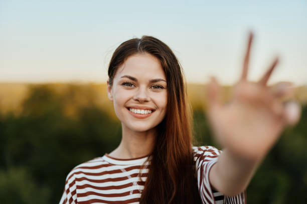 istock Woman smiling while looking at the camera and pulling her hands to the camera close-up in nature with a view of the mountains. Happy travel lifestyle follow me 2148319505