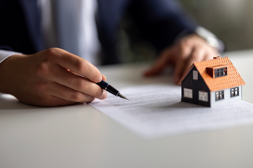 Real estate agent discuss about the terms of the home purchase agreement and asked the customer to sign the documents to make the contract legally, Home sales, lease, mortgage and home insurance.