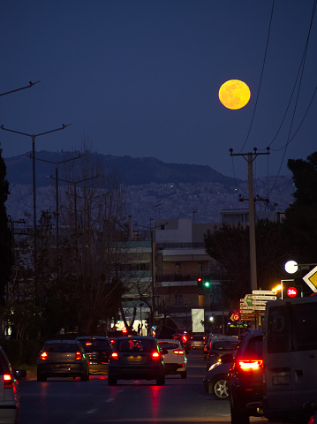 City road traffic in the view of a full moon