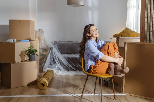 istock Happy young woman with moving boxes in new home. New beginnings 2148321098