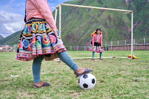 Women soccer players of the Quechua ethnic group in the Cusco region play soccer with their typical costumes called poyeras