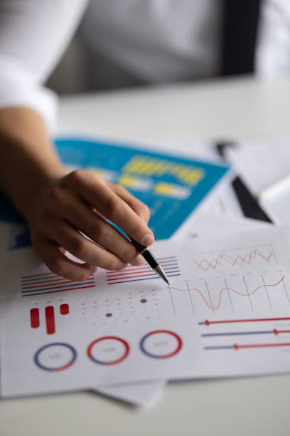 Close-up of businessman analyzing chart and graph showing changes on the market.