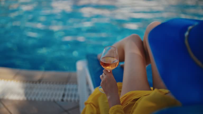 Woman in blue hat is relaxing near the pool.