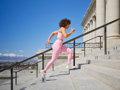 A woman running up the steps of the Utah State Capitol building for exercise in Salt Lake City, Utah USA.