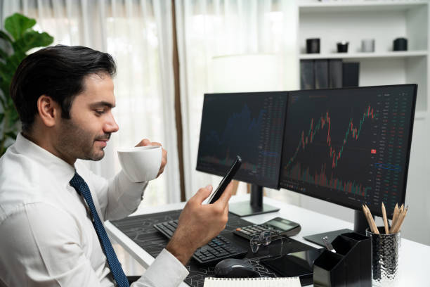 istock Trader analyzing holding coffee cup focusing on phone and stock screen. Surmise. 2148323589