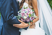 wedding day, the bride and groom are holding a wedding bouquet, faces are not visible 1