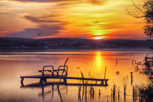 Amazing Dramatic sunset over the lake. Dock on the lake at sunset. Dramatic sky