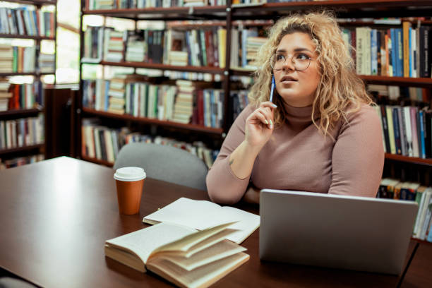 istock Pensive and Thoughtful Female Student Studying Alone in Library 2148325925