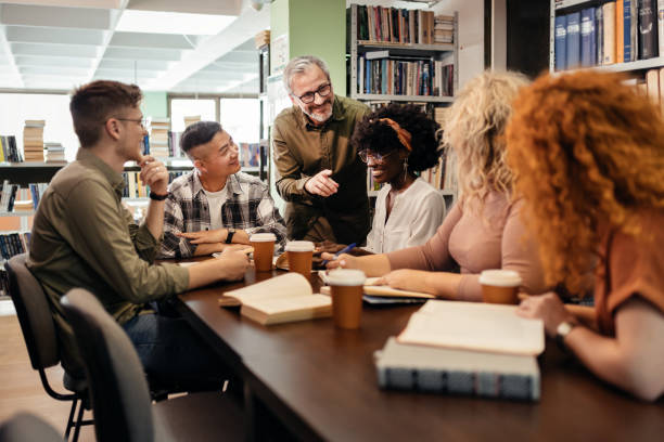 istock Tutor Working With Group of Multiracial Students at Library 2148326133