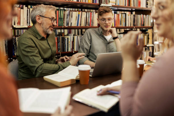 istock College Students Working in Library Being Helped by Male Teacher 2148326207